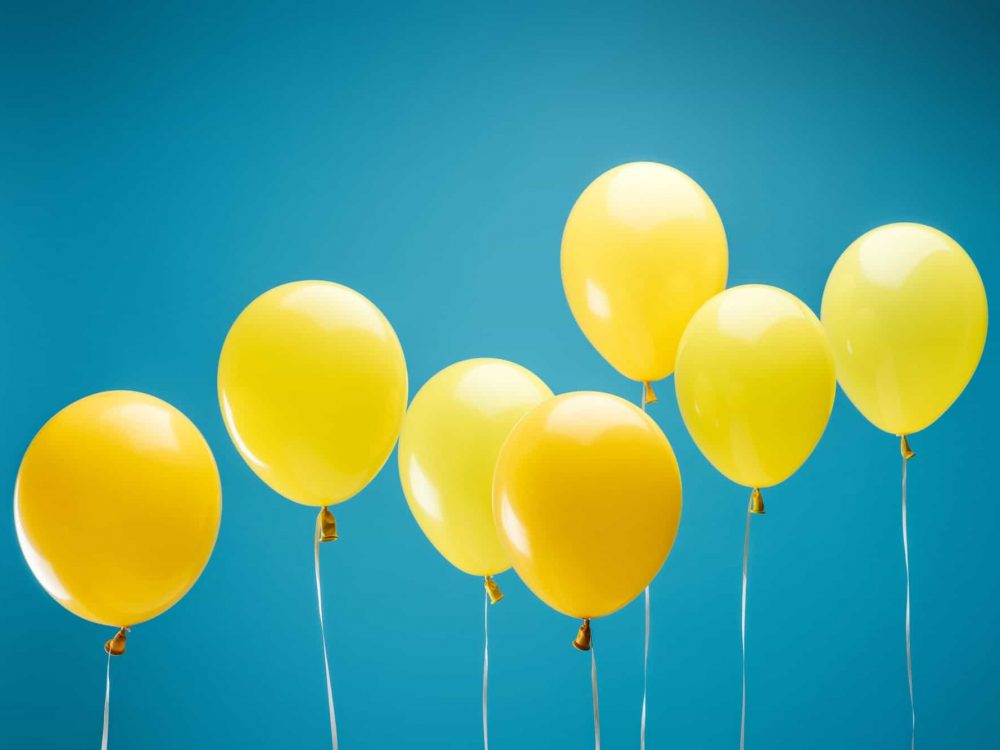 bright party yellow balloons on blue background