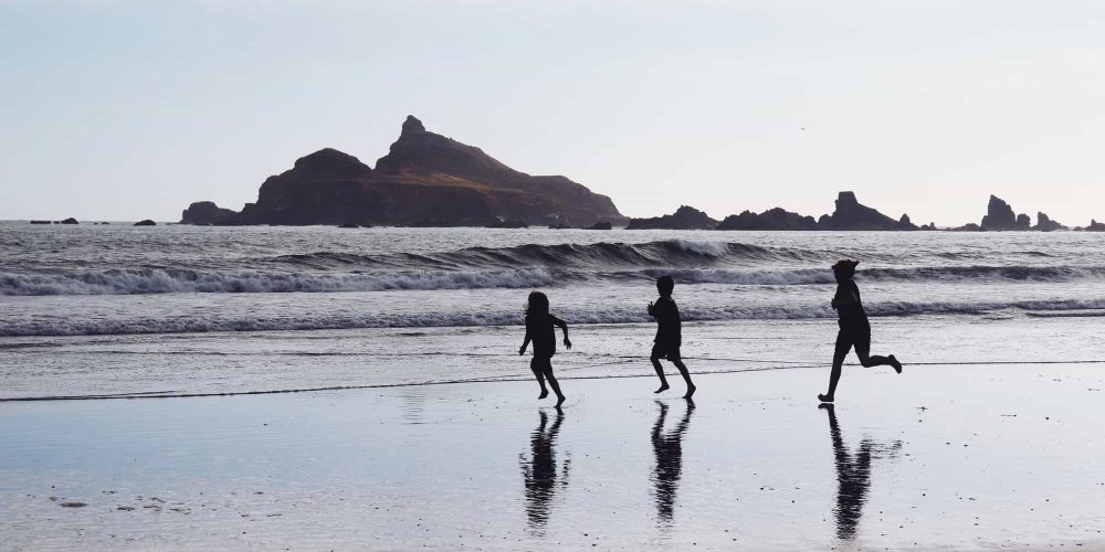 Children running on beach in silhouette. Children running on beach in silhouette.