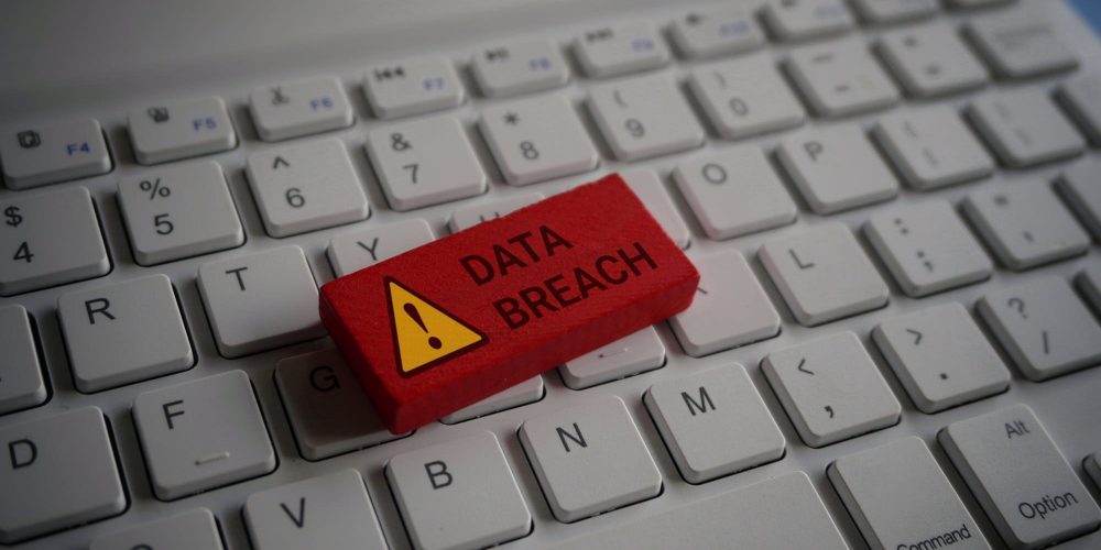 Close up image of computer keyboard and red wooden cube with text DATA BREACH.