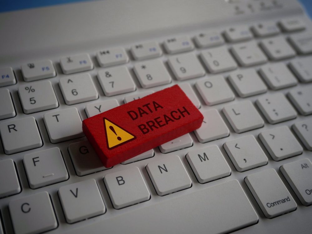Close up image of computer keyboard and red wooden cube with text DATA BREACH.