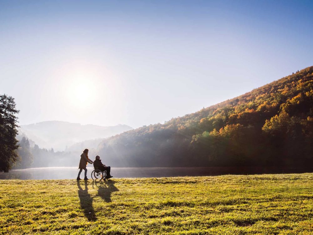 Senior couple with wheelchair in autumn nature.