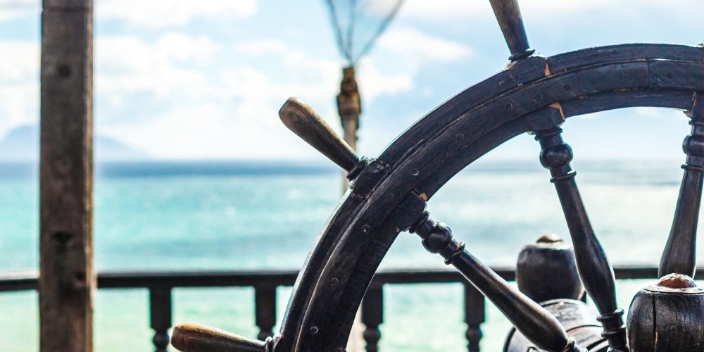 Wooden steering wheel of a ship on the background of the sea