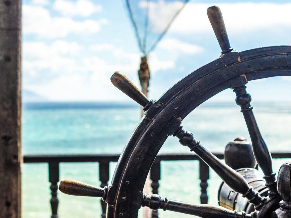 Wooden steering wheel of a ship on the background of the sea
